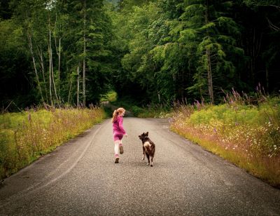 girl running on path with dog